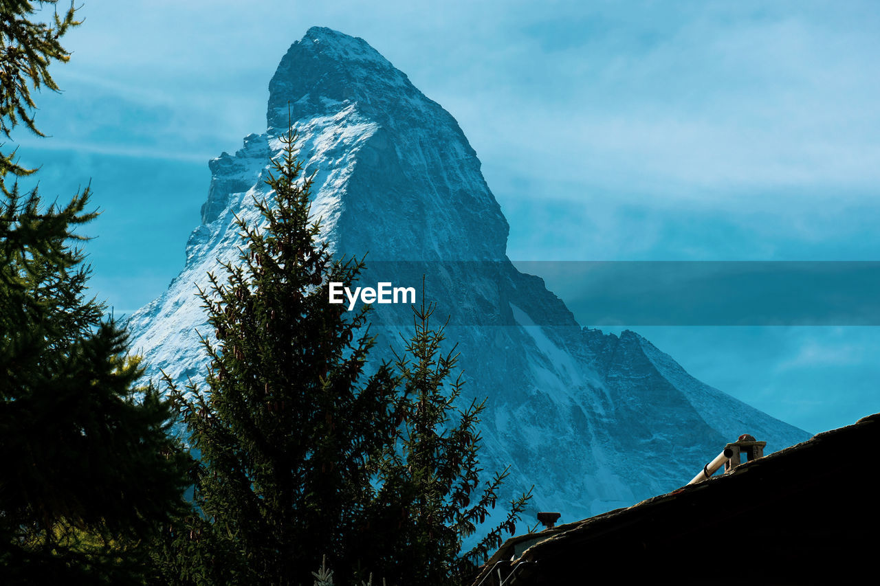 Scenic view of mountains against sky with trees