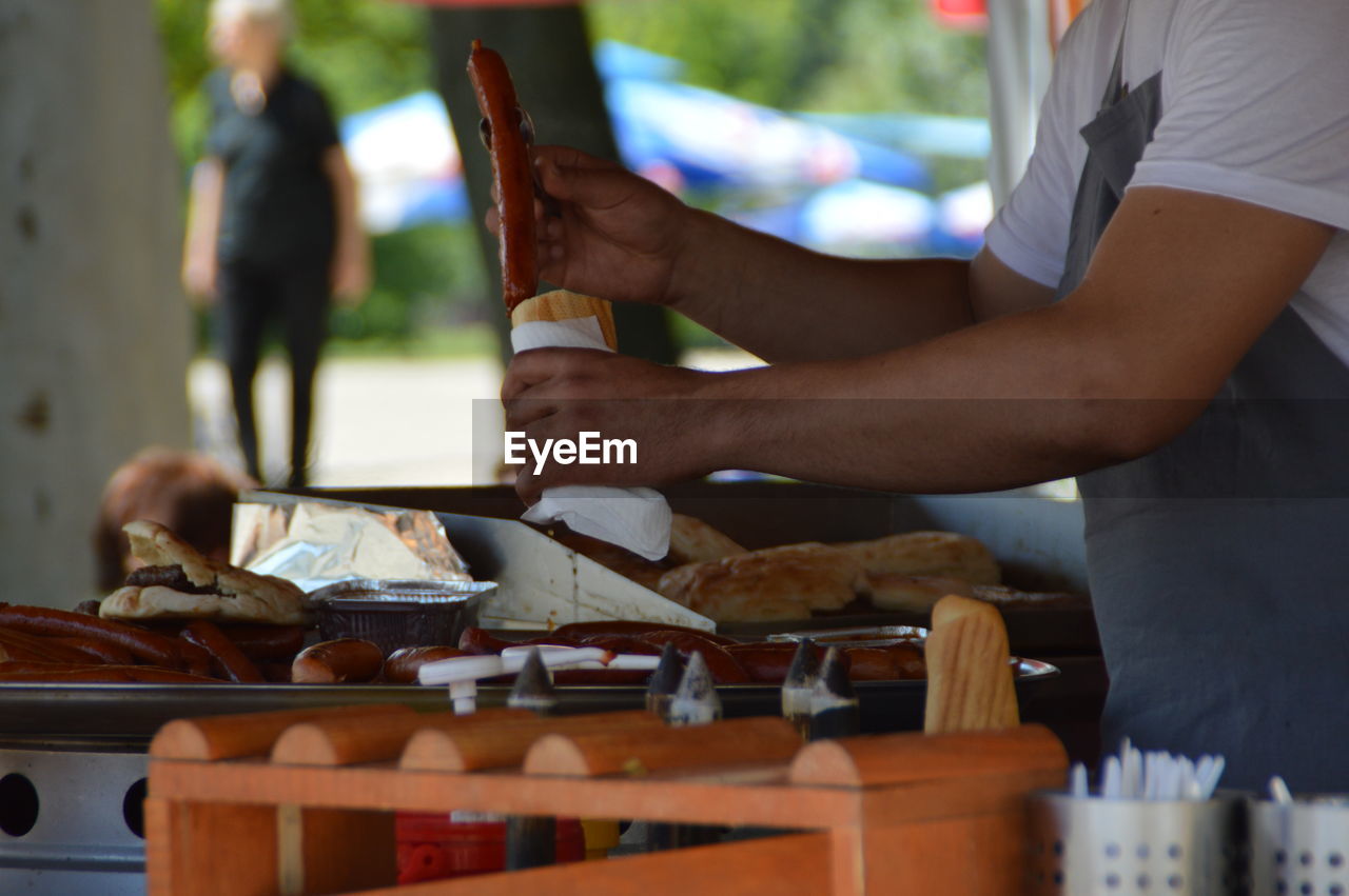 Midsection of man making food at cafe