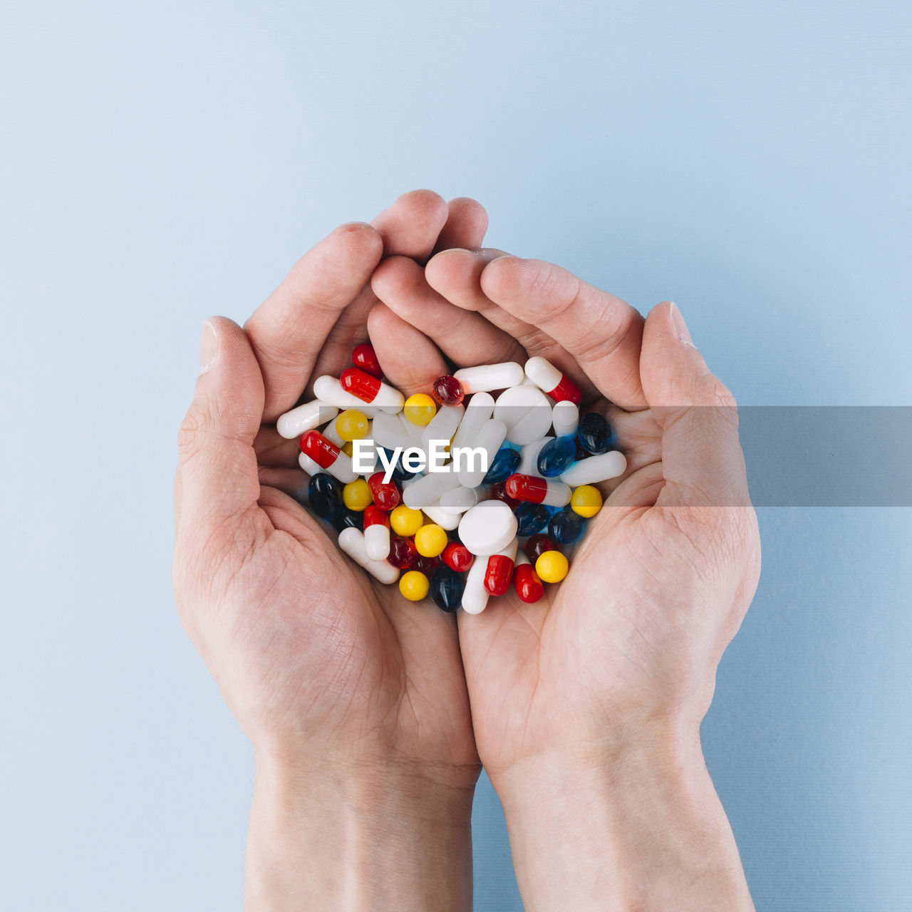 cropped hand of woman holding toy blocks against blue background