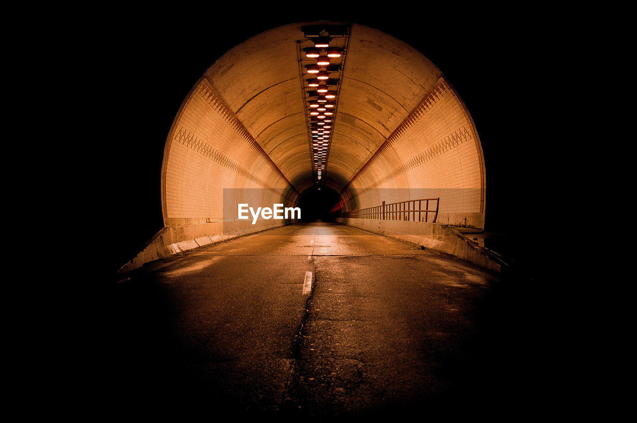 ILLUMINATED TUNNEL WITH LIGHT AT NIGHT