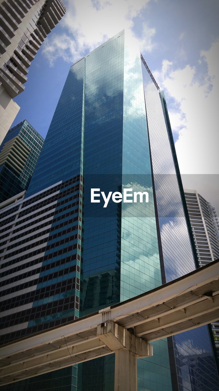 Low angle view of modern building against cloudy sky