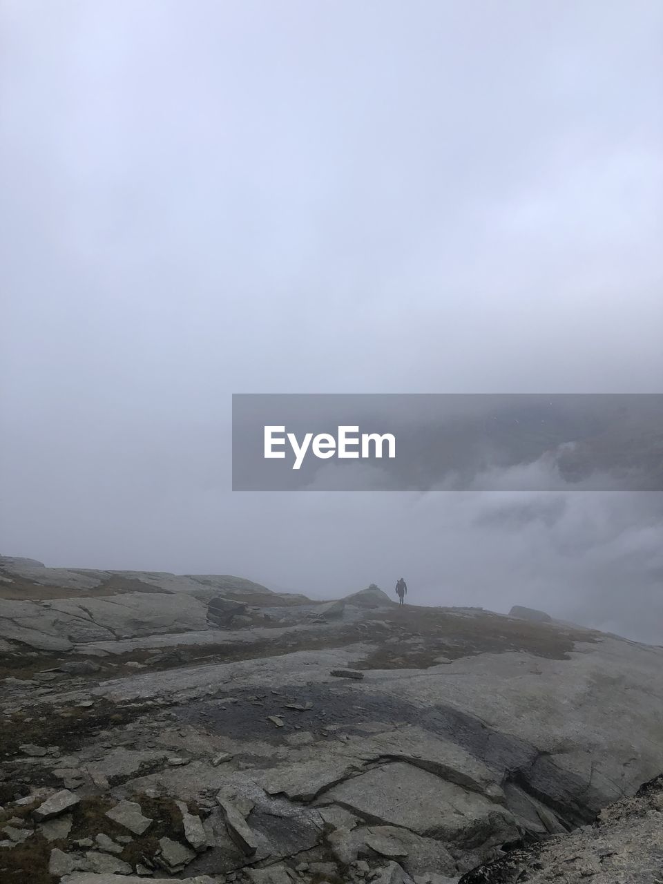 cloud, nature, sky, rock, beauty in nature, no people, outdoors, low angle view, day, fog, environment, scenics - nature, mountain, cliff, storm, rock formation, tranquility, geology