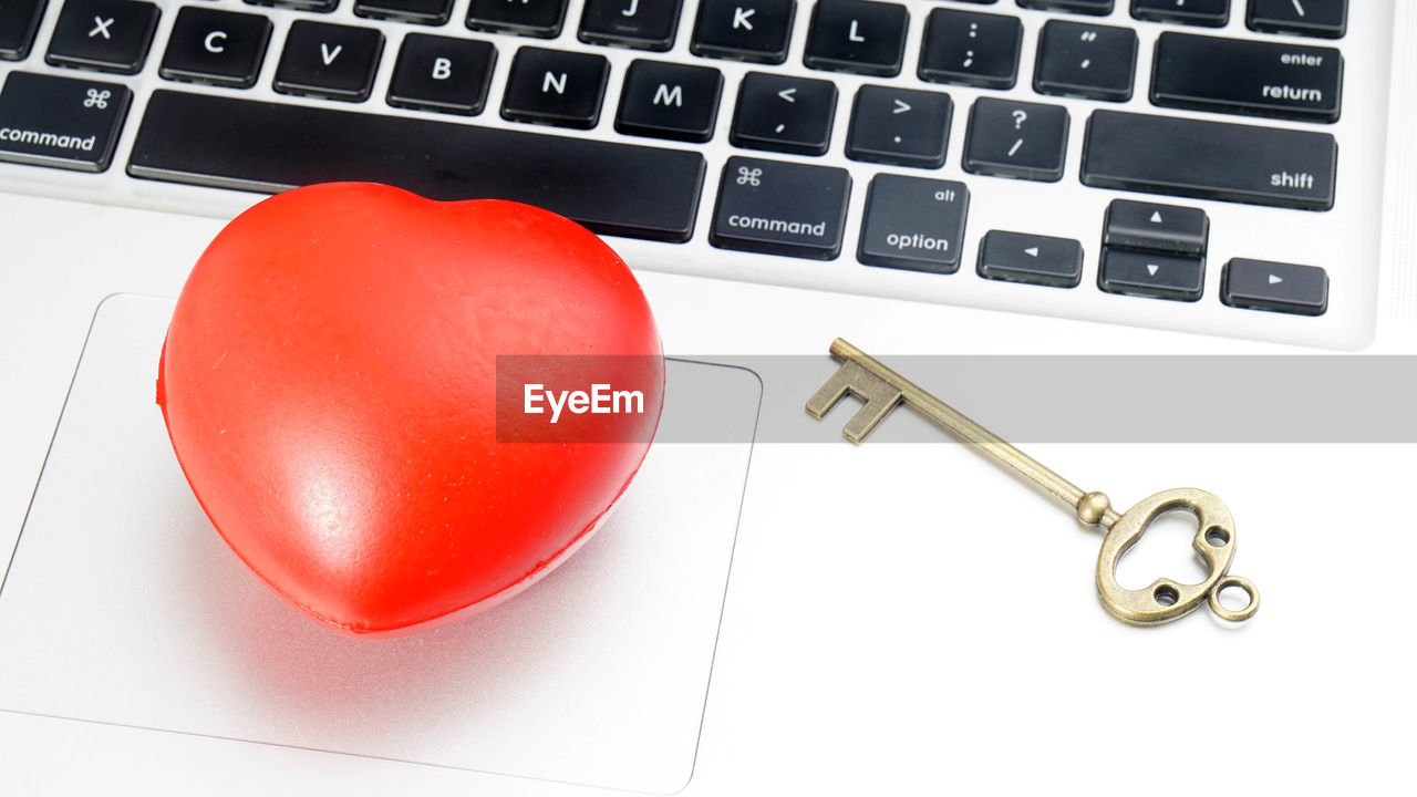 High angle view of heart shape and key on laptop