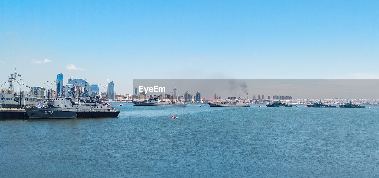 Boats in sea against clear sky