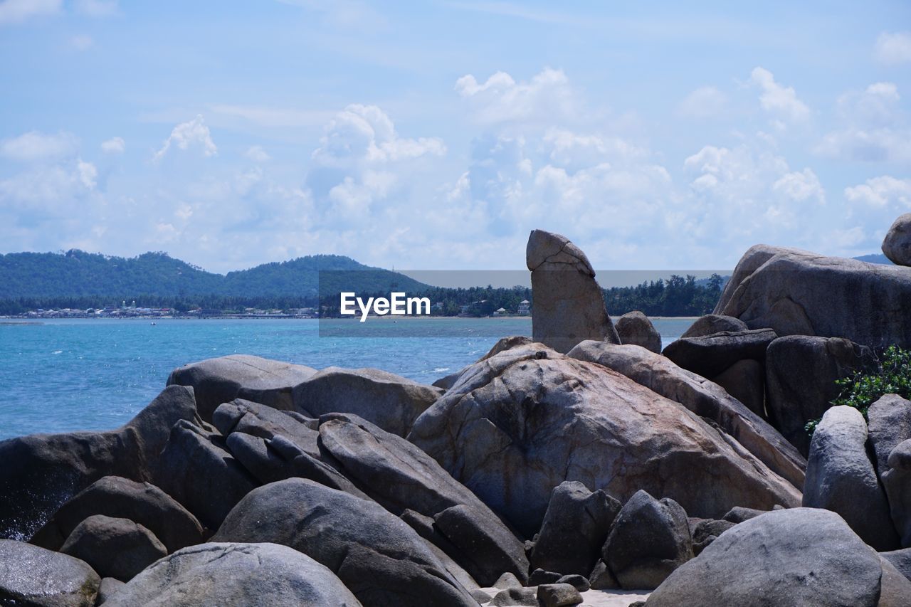 Rocks by sea against sky