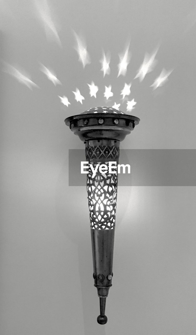 LOW ANGLE VIEW OF ILLUMINATED LAMP AGAINST LIGHT BULB