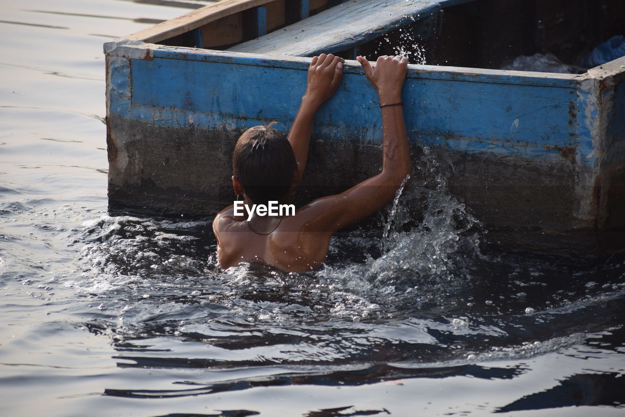 Rear view of shirtless boy in swimming