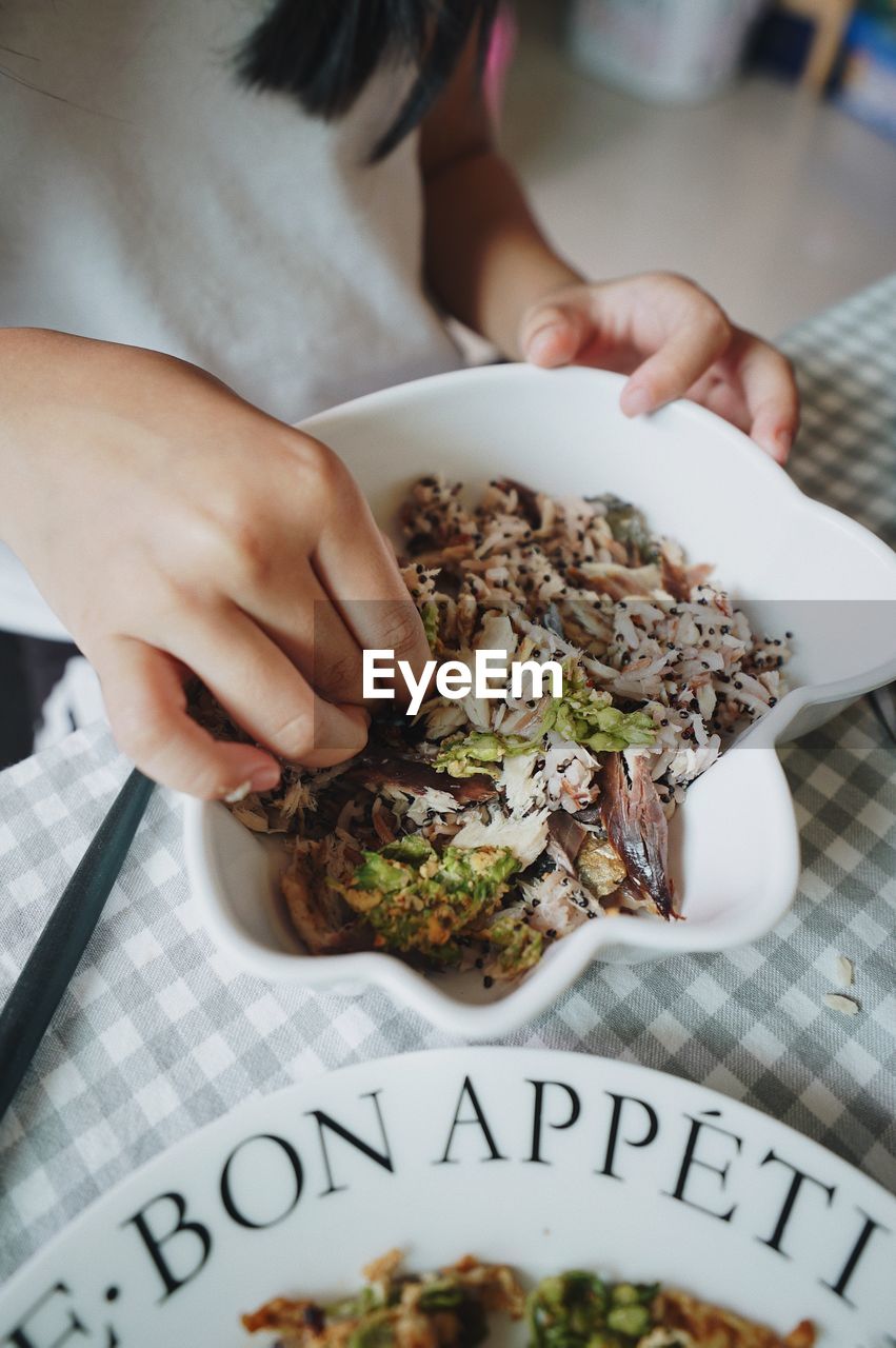 Midsection of woman having food in home