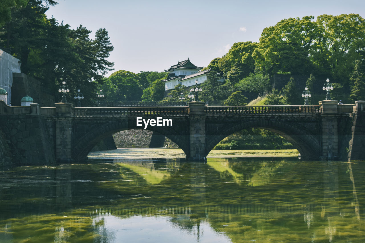 Arch bridge over river against sky