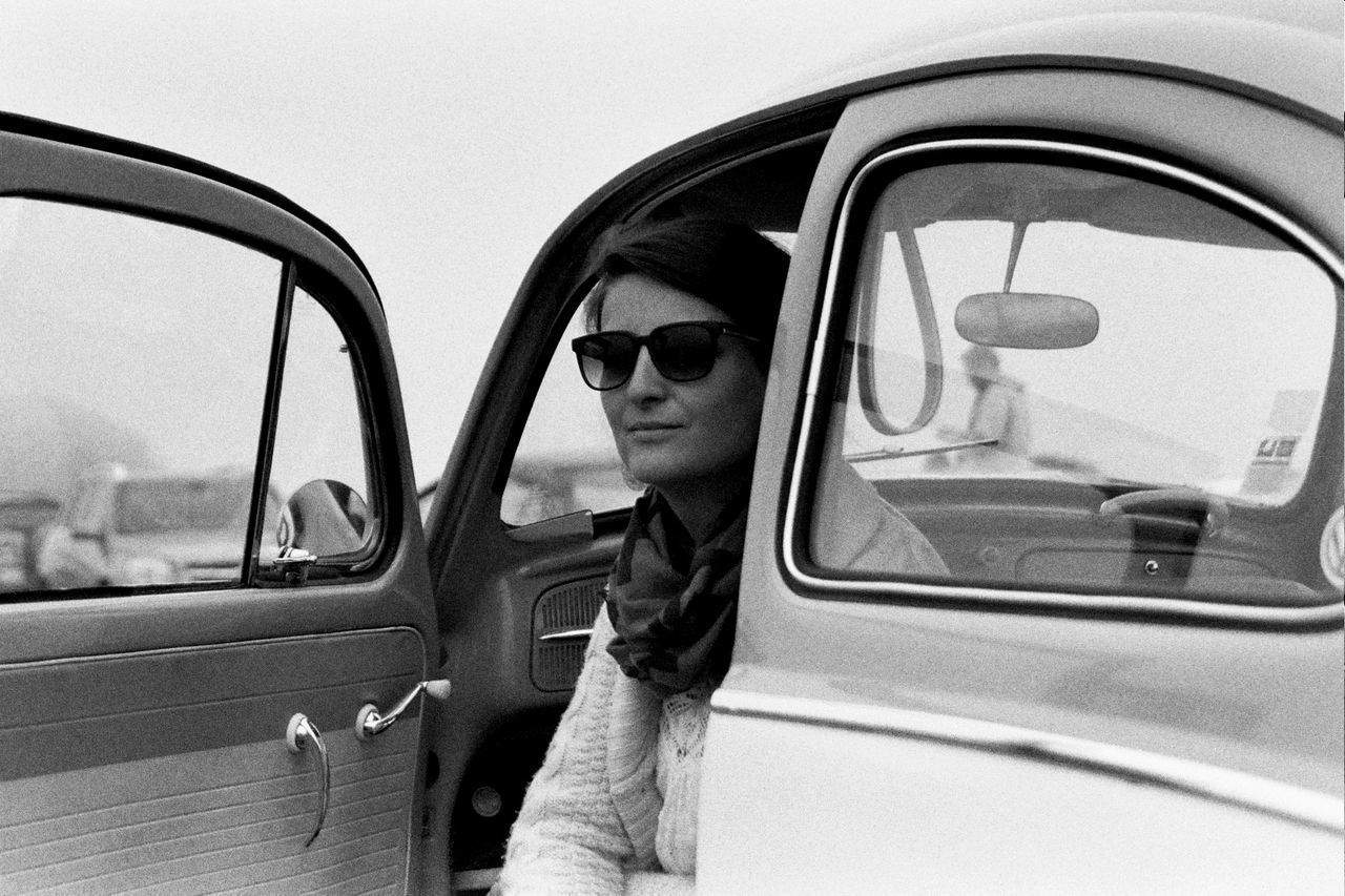 Woman sitting in car against clear sky