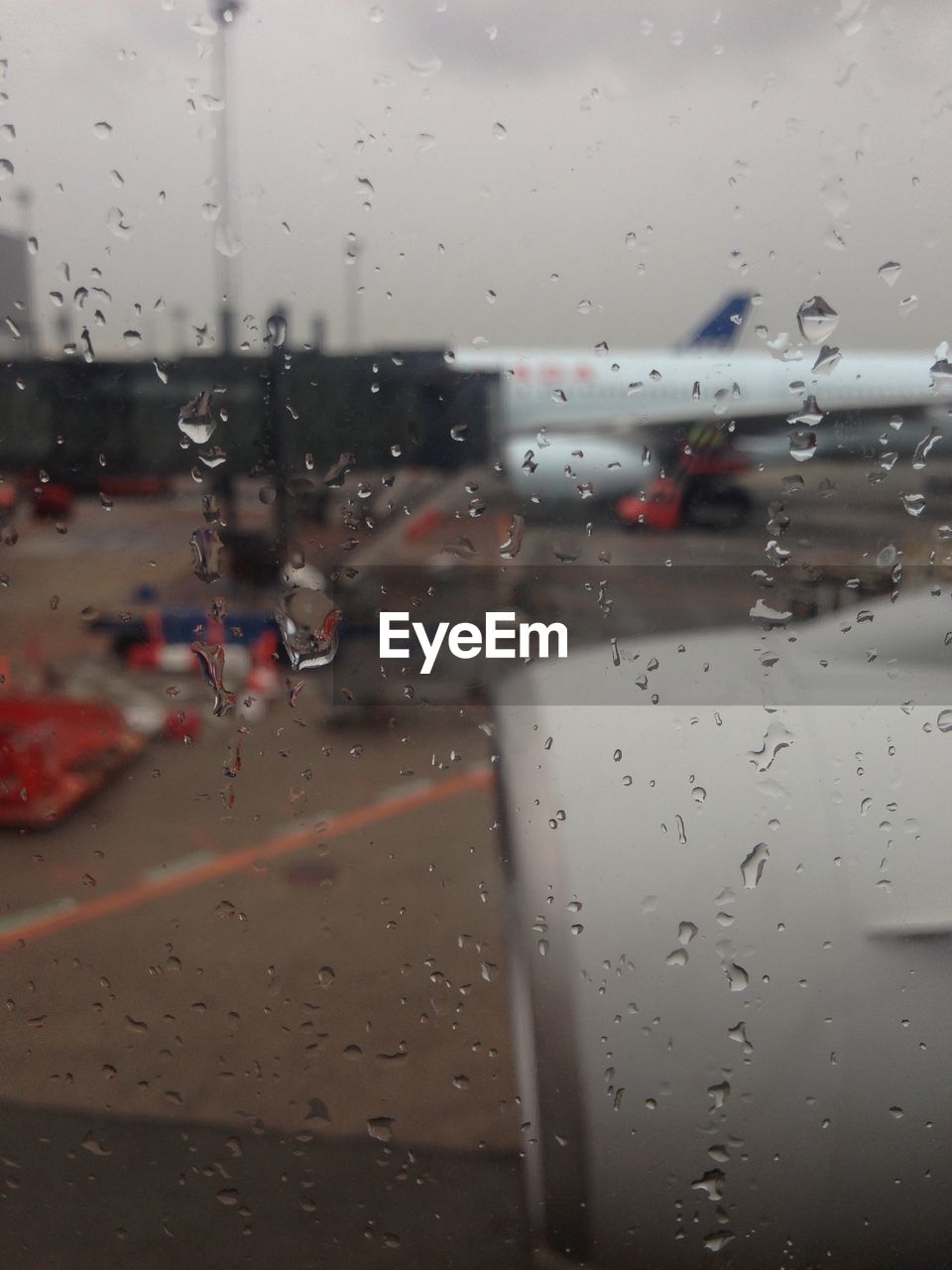Waterdrops on glass with view of airport terminal