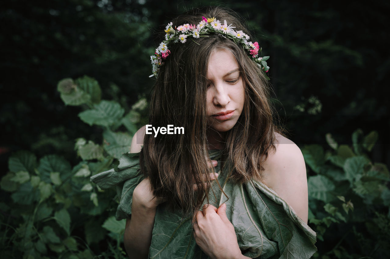 Beautiful young woman with crown in the forest