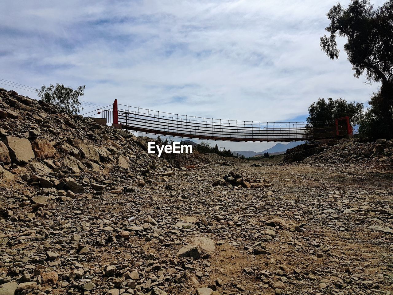 LOW ANGLE VIEW OF BRIDGE AND ROCKS AGAINST SKY