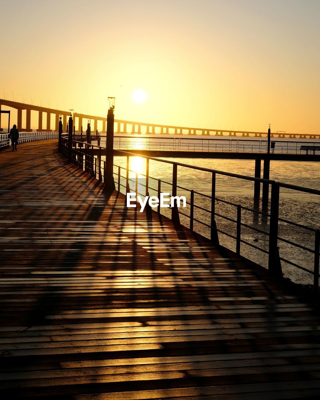 Pier over sea against sky during sunset