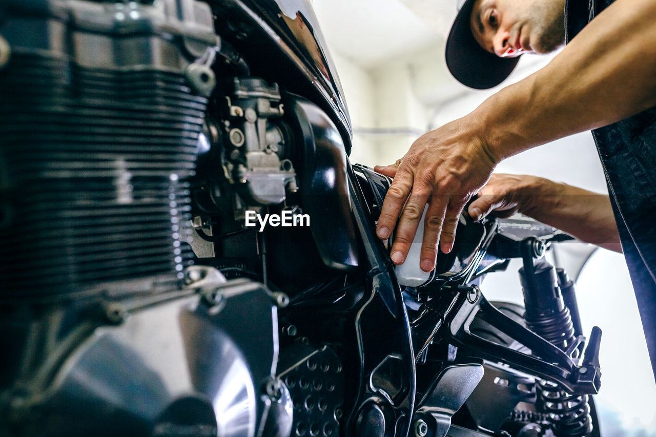 Mature mechanic repairing motorcycle in garage