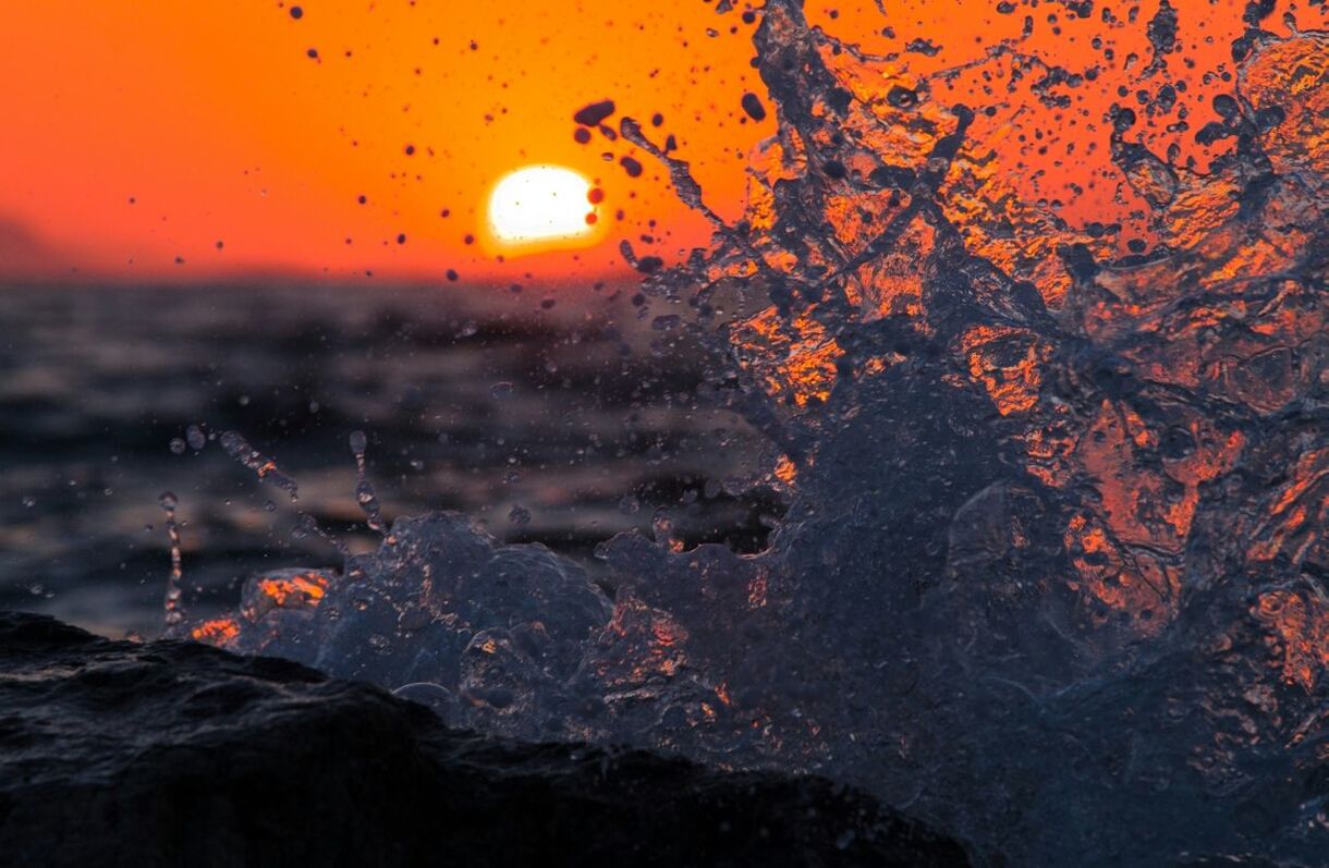 Close-up of splashing water against sunset