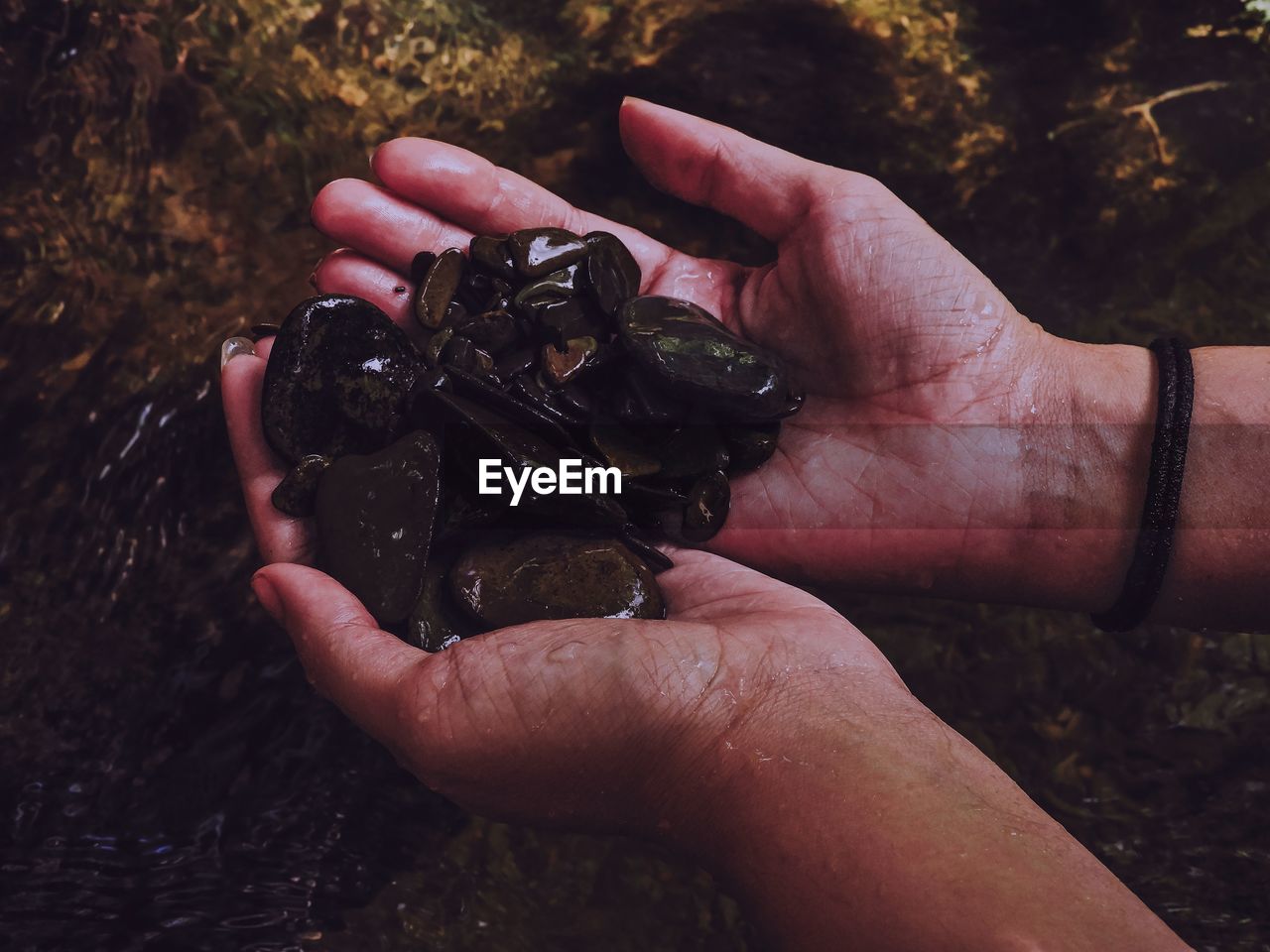 Cropped hands holding stones