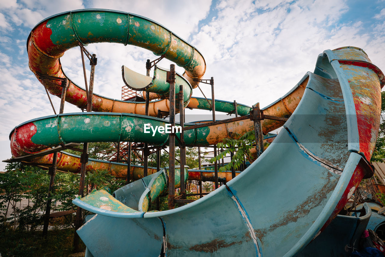 Close-up of old water slide against sky