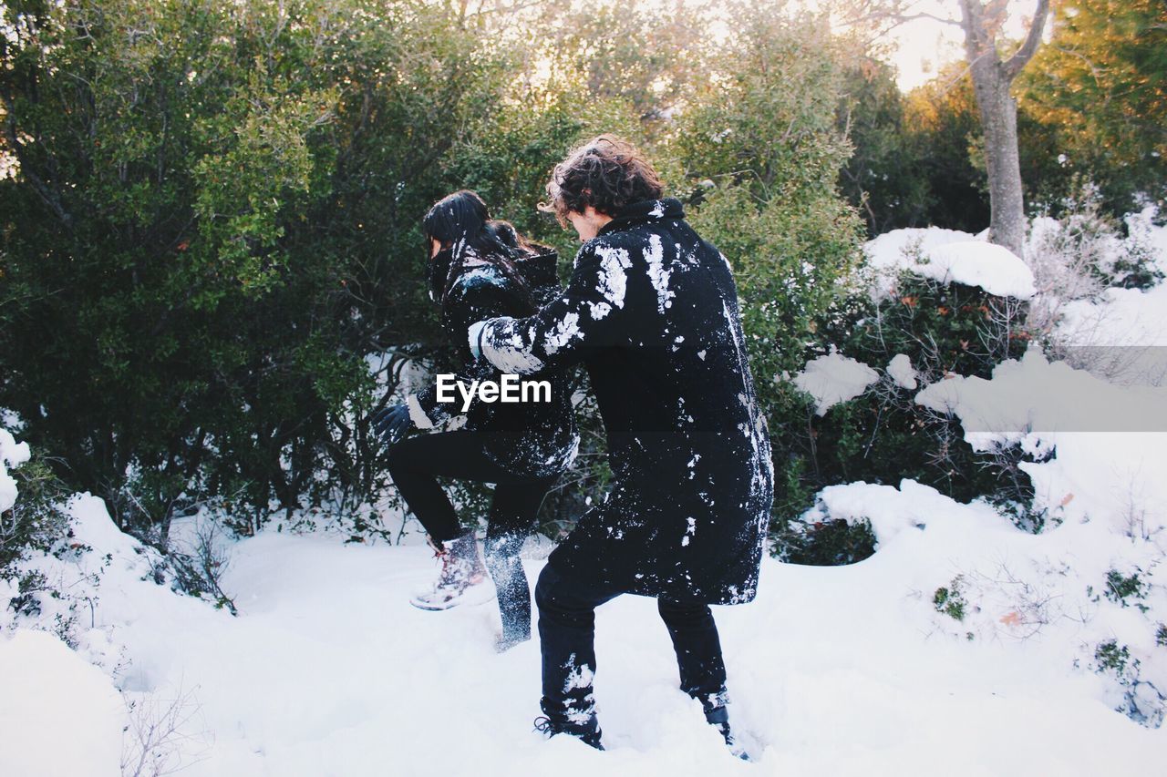 Man and woman playing on snow covered field