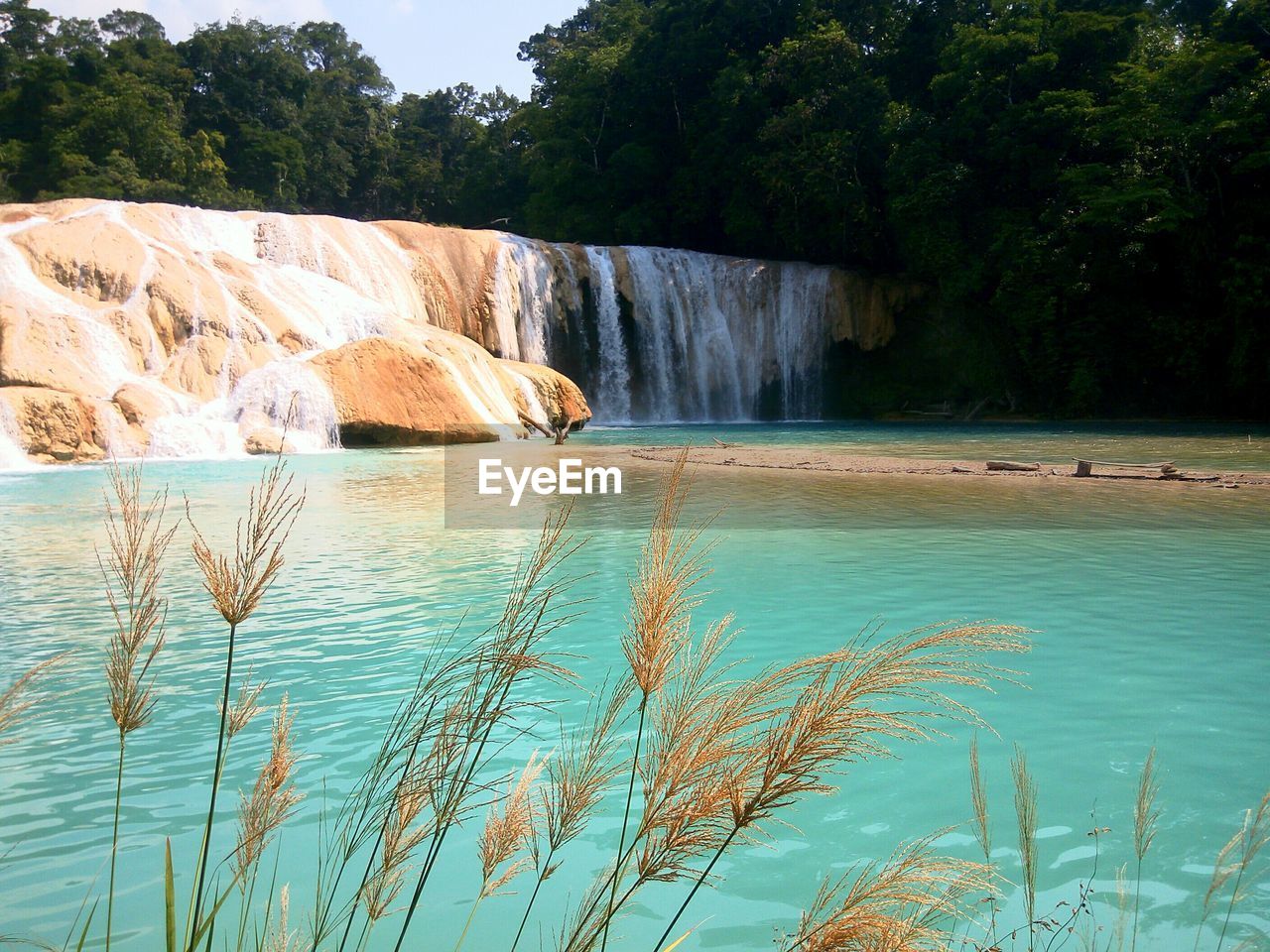 Scenic view of waterfall against sky