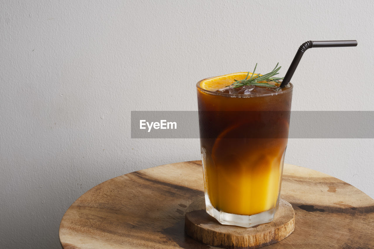 CLOSE-UP OF DRINK IN GLASS ON TABLE