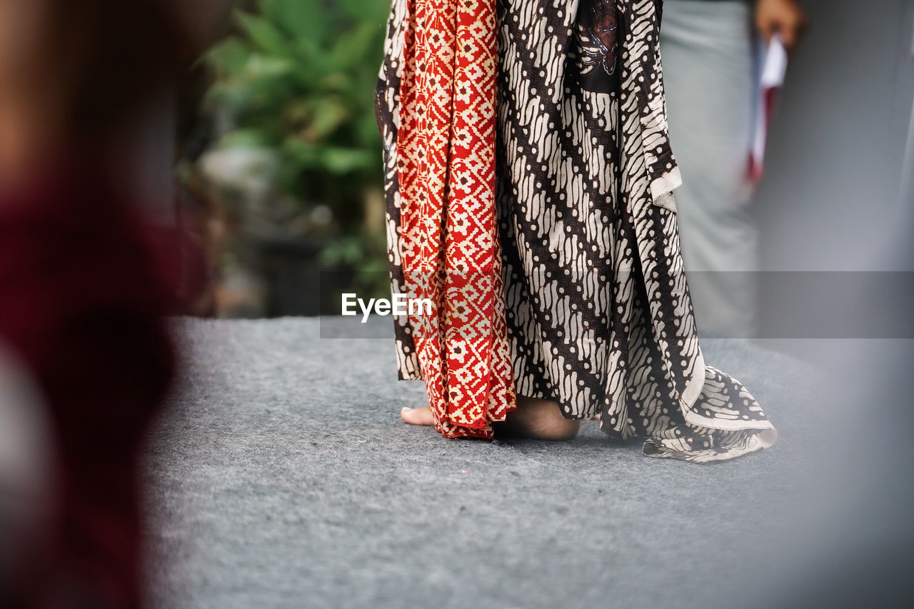 red, low section, fashion, spring, adult, women, selective focus, human leg, dress, day, clothing, footwear, city, walking, street, outdoors, standing, one person, limb, human limb, lifestyles