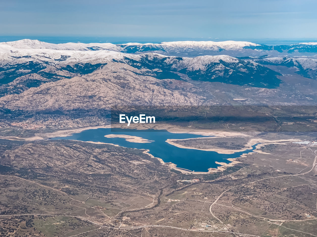 Aerial view of snowcapped mountains and lake against sky