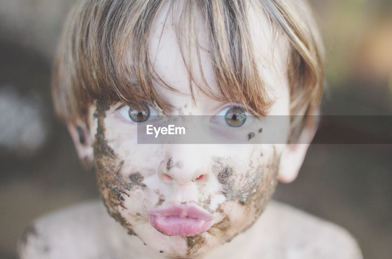 Close-up portrait of boy with dirty face