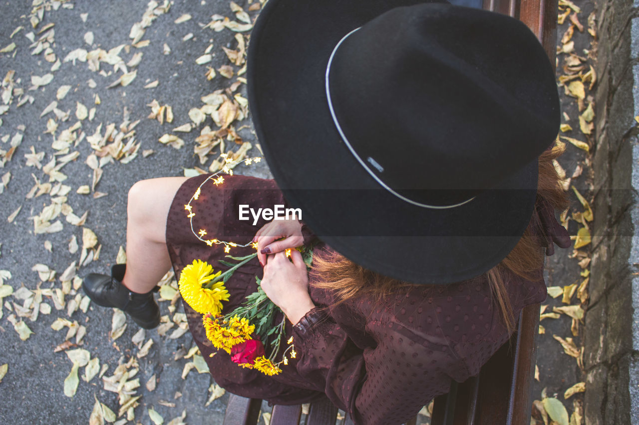 High angle view of woman wearing hat standing by leaves