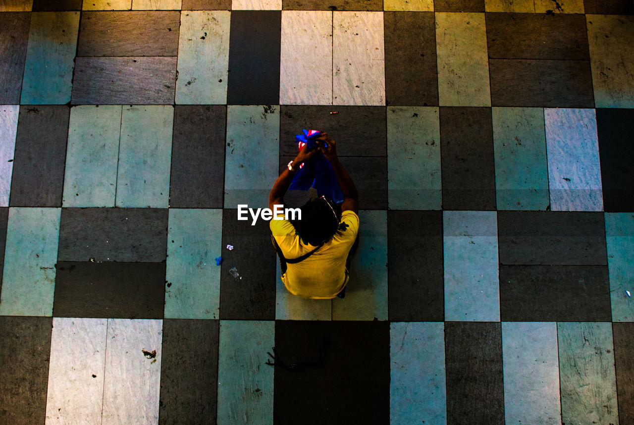 High angle view of person sitting on floor