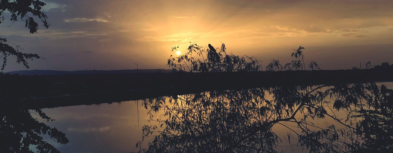 SILHOUETTE TREES BY LAKE AGAINST SKY AT SUNSET