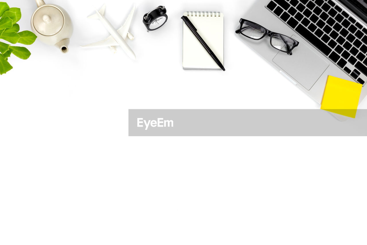 High angle view of laptop with eyeglasses over white background