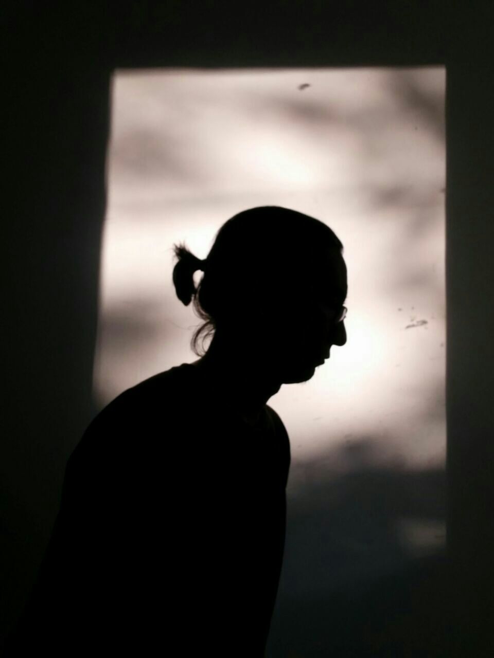 Silhouette man standing against wall