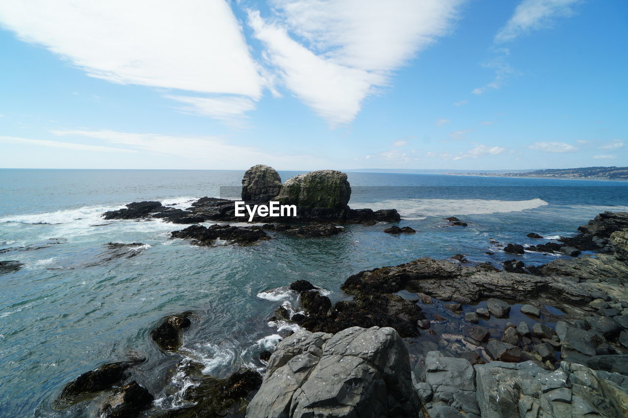 SCENIC VIEW OF ROCKS ON SEA AGAINST SKY