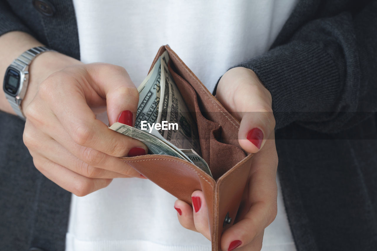 Midsection of woman holding wallet