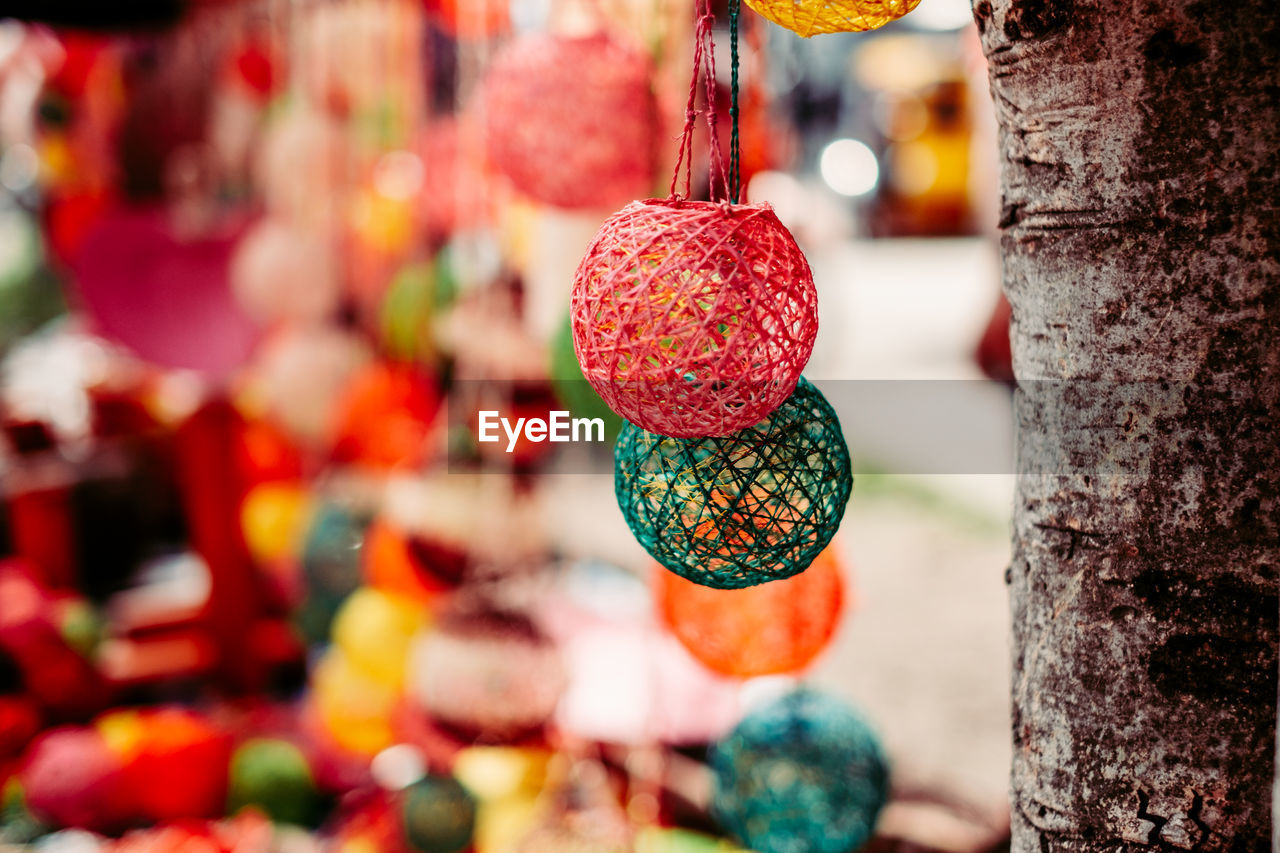 Close-up of decoration hanging by tree trunk