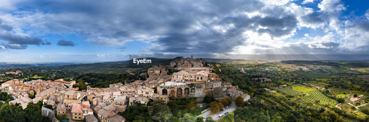 Italy, province of siena, montepulciano, helicopter panorama of medieval hill town in val dorcia at cloudy sunset