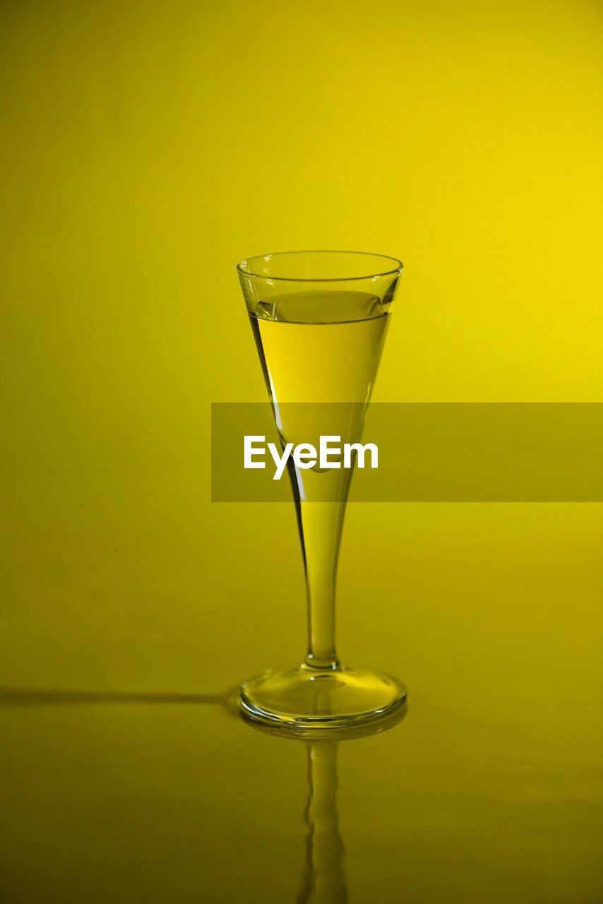 Close-up of wineglass against yellow background