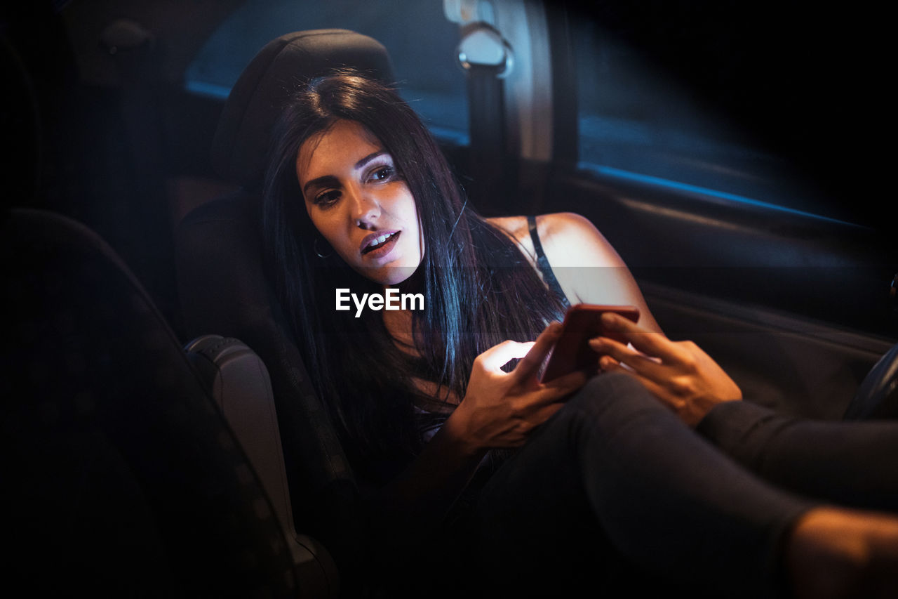 Woman inside a car using her smartphone