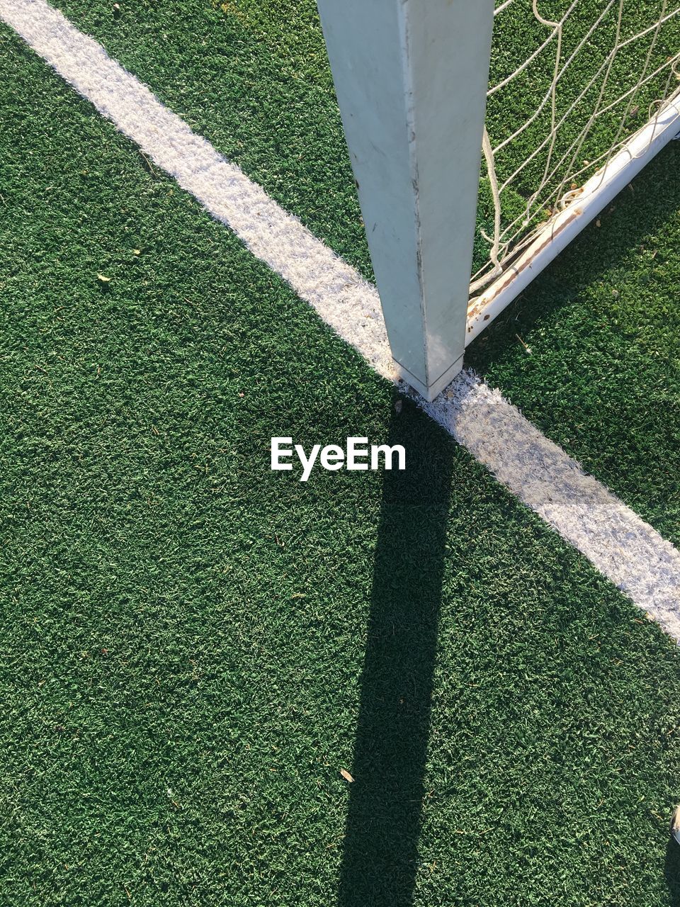 HIGH ANGLE VIEW OF SHADOW ON FIELD BY WALL