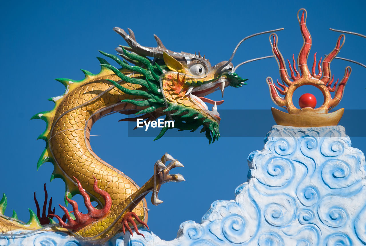 Low angle view of chinese dragon statue against clear sky