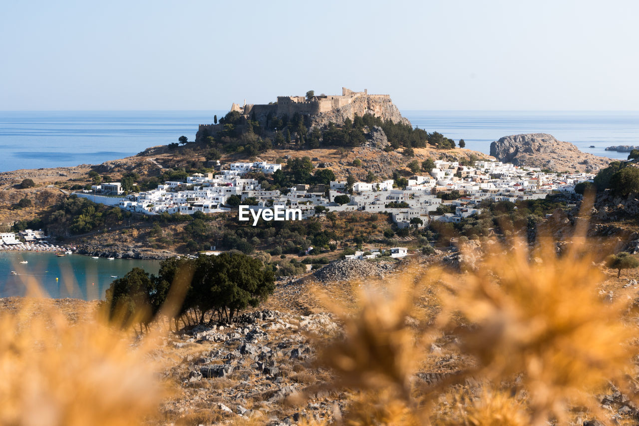 SCENIC VIEW OF SEA BY TOWNSCAPE AGAINST SKY