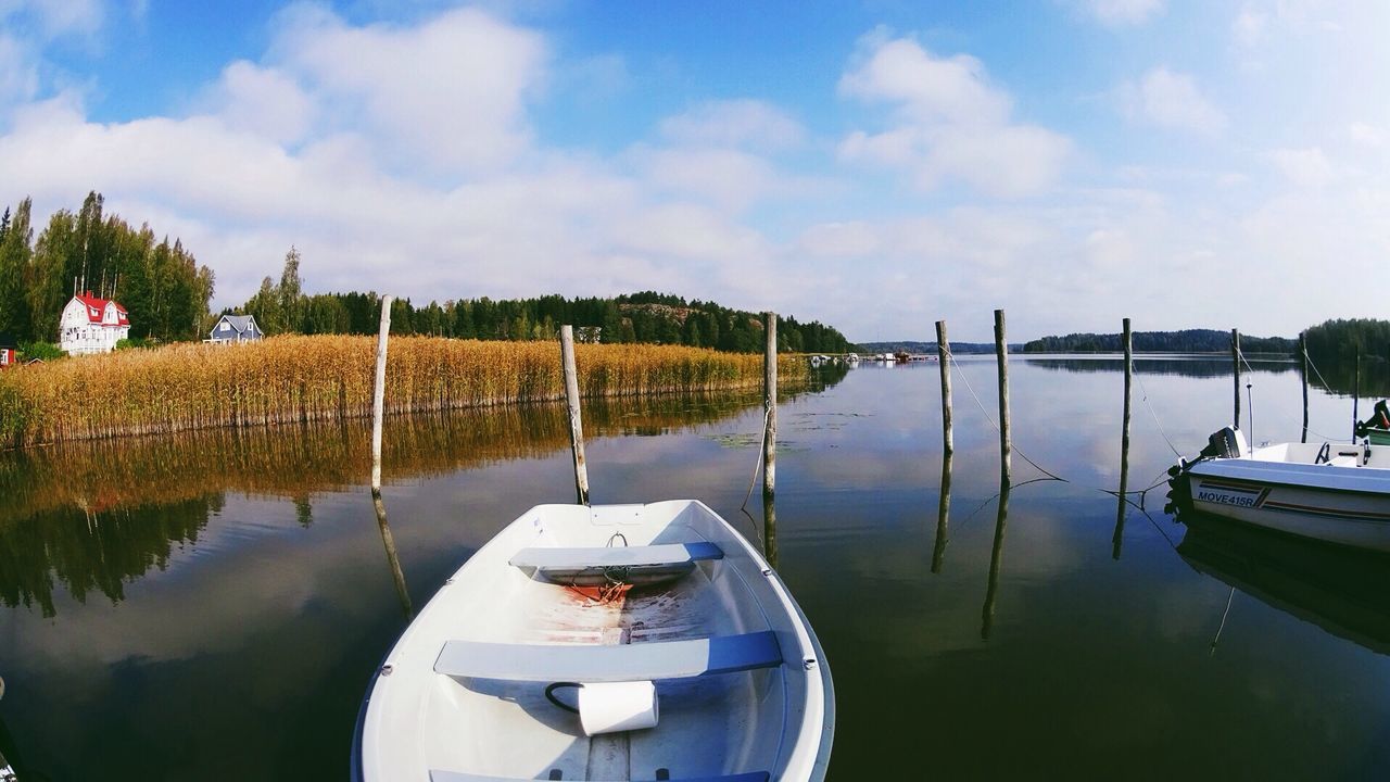 Boats moored in river against sky