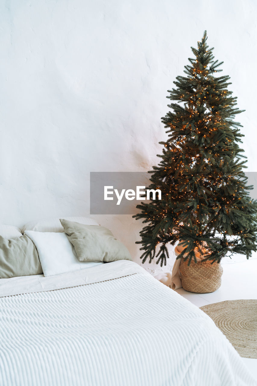 Decorated christmas tree at bedroom in eco bright interior at home