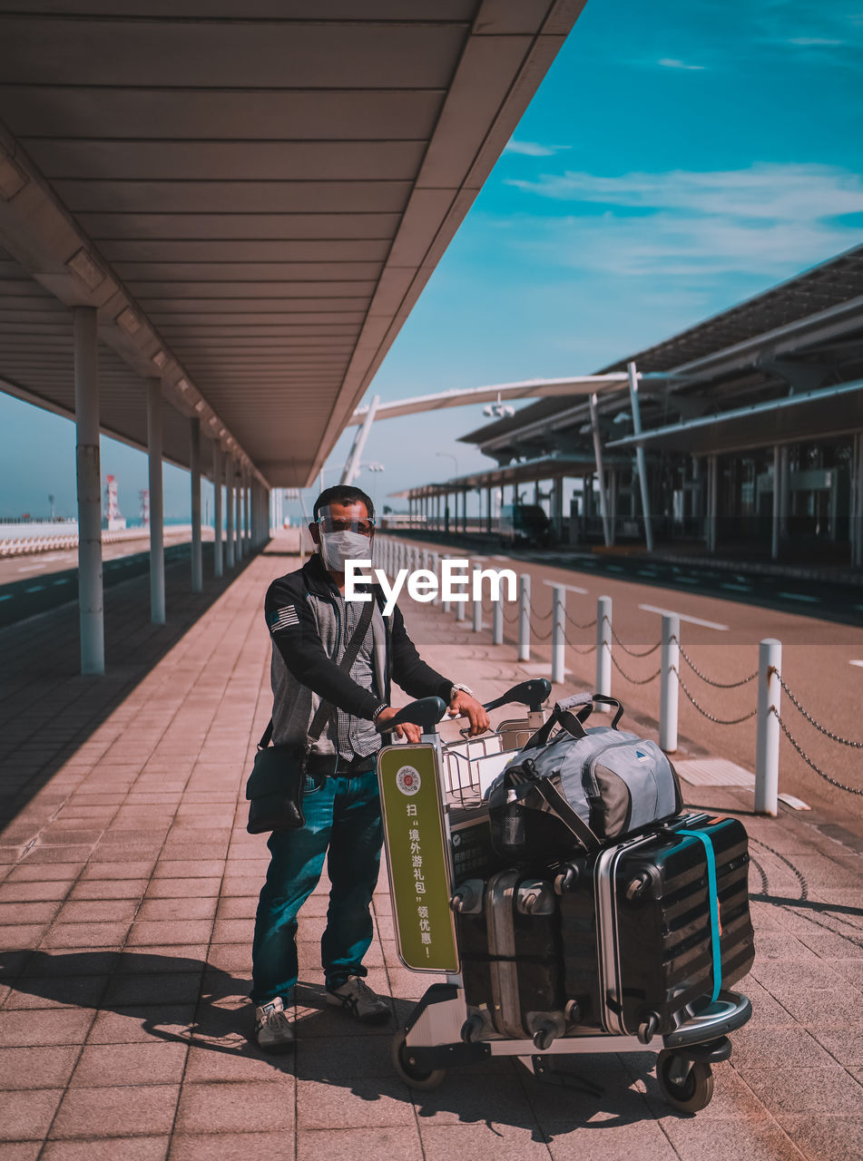 MAN STANDING AT RAILROAD STATION PLATFORM