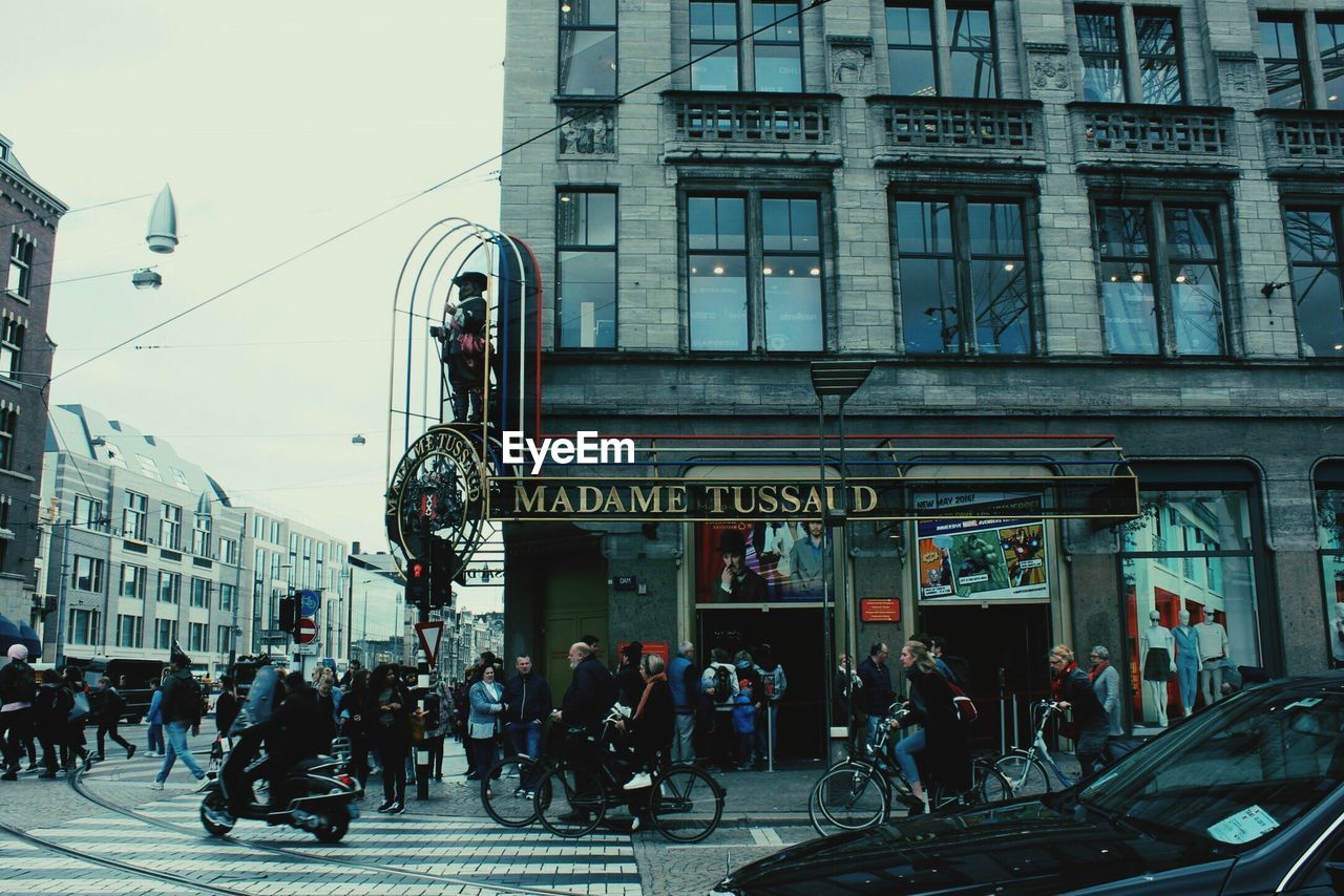 PEOPLE ON STREET AGAINST BUILDINGS