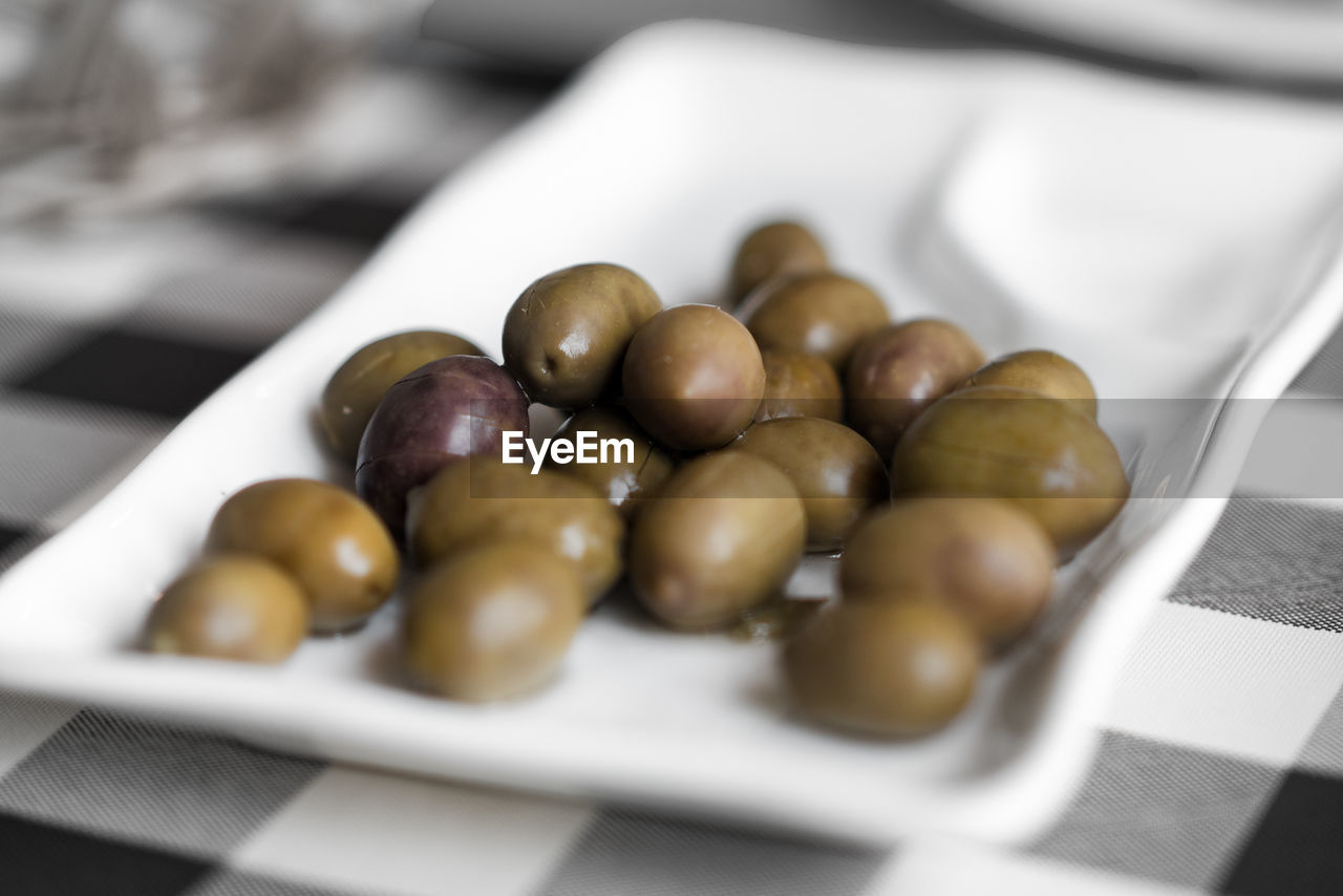 High angle view of olives in plate on table