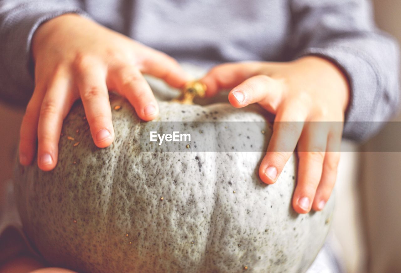 Midsection of woman holding pumpkin