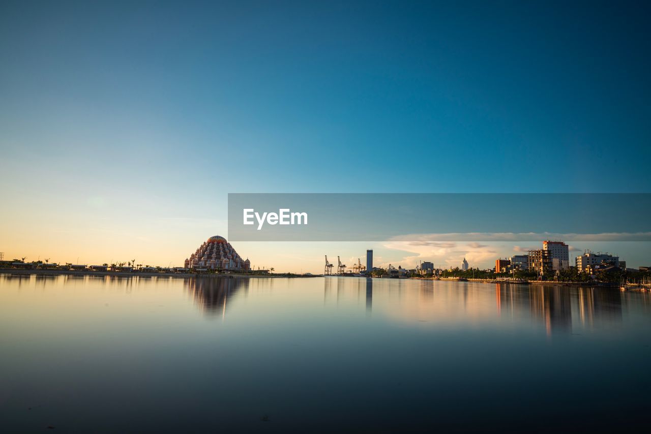 Scenic view of river against sky at sunset