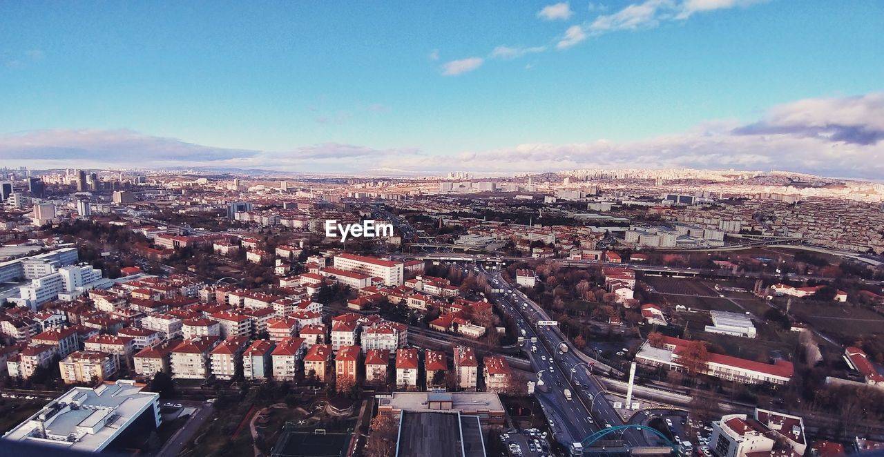 HIGH ANGLE VIEW OF BUILDINGS IN CITY AGAINST SKY
